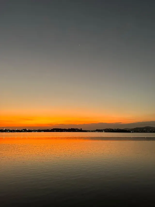 Entardecer alaranjado refletido no mar calmo