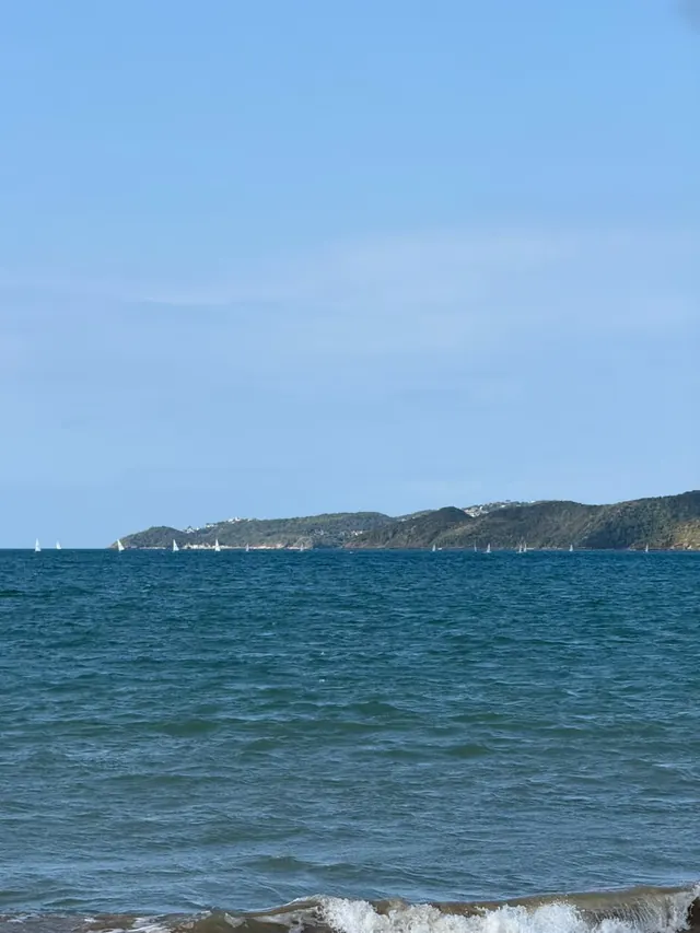 Mar azul com a costa ao fundo